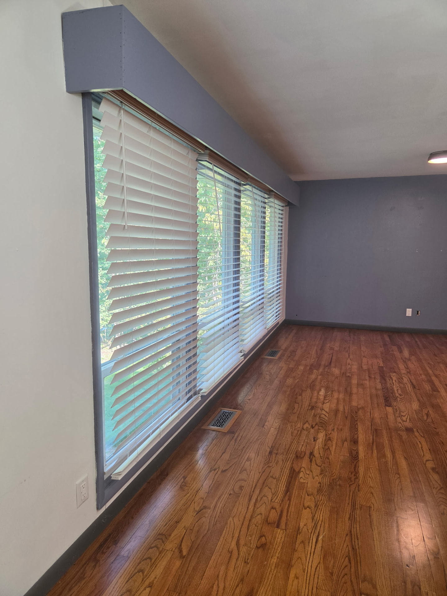 Before painting: gray living room walls and window trim