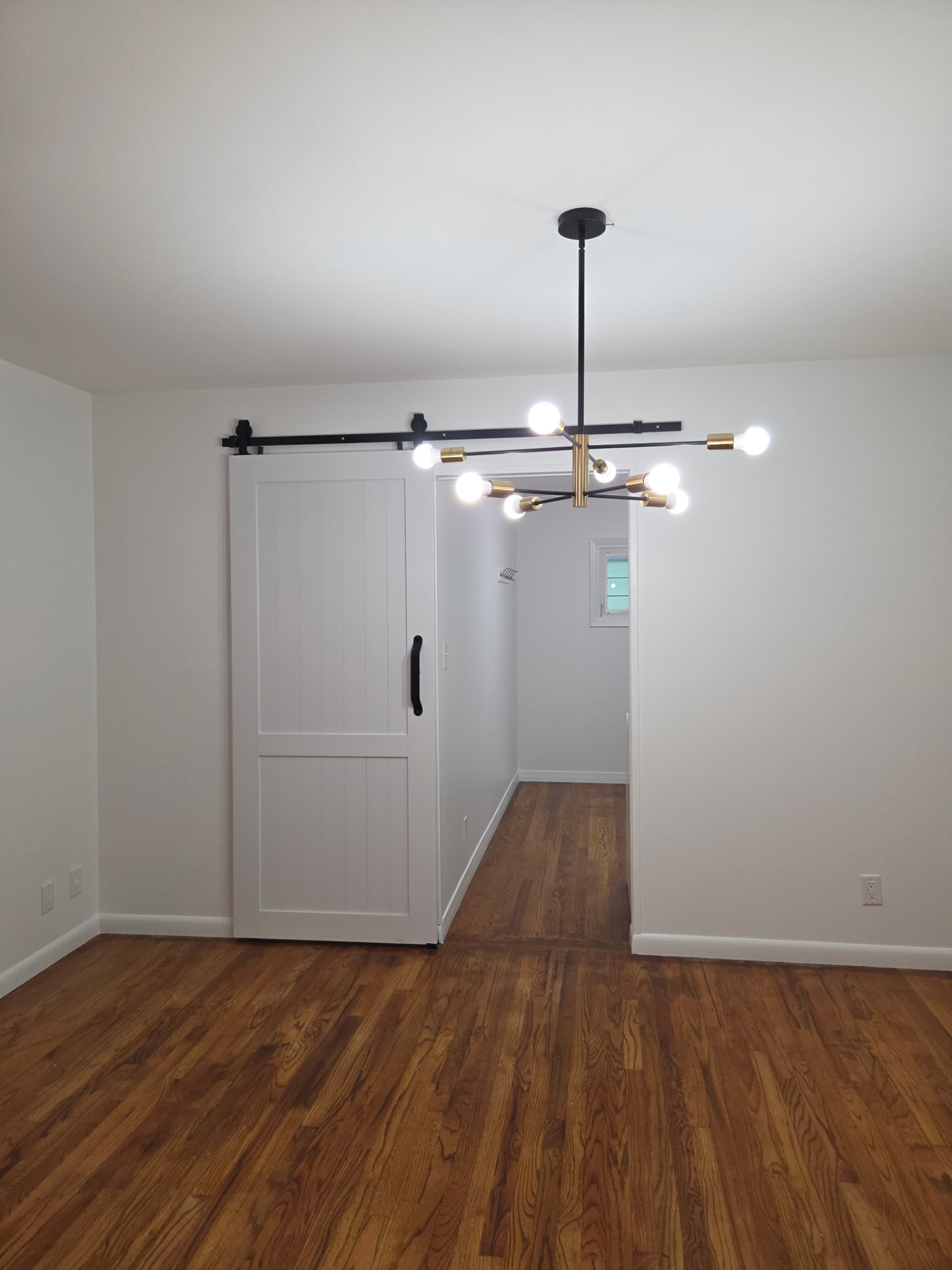 After painting: crisp white dining room walls beside a sliding barn door