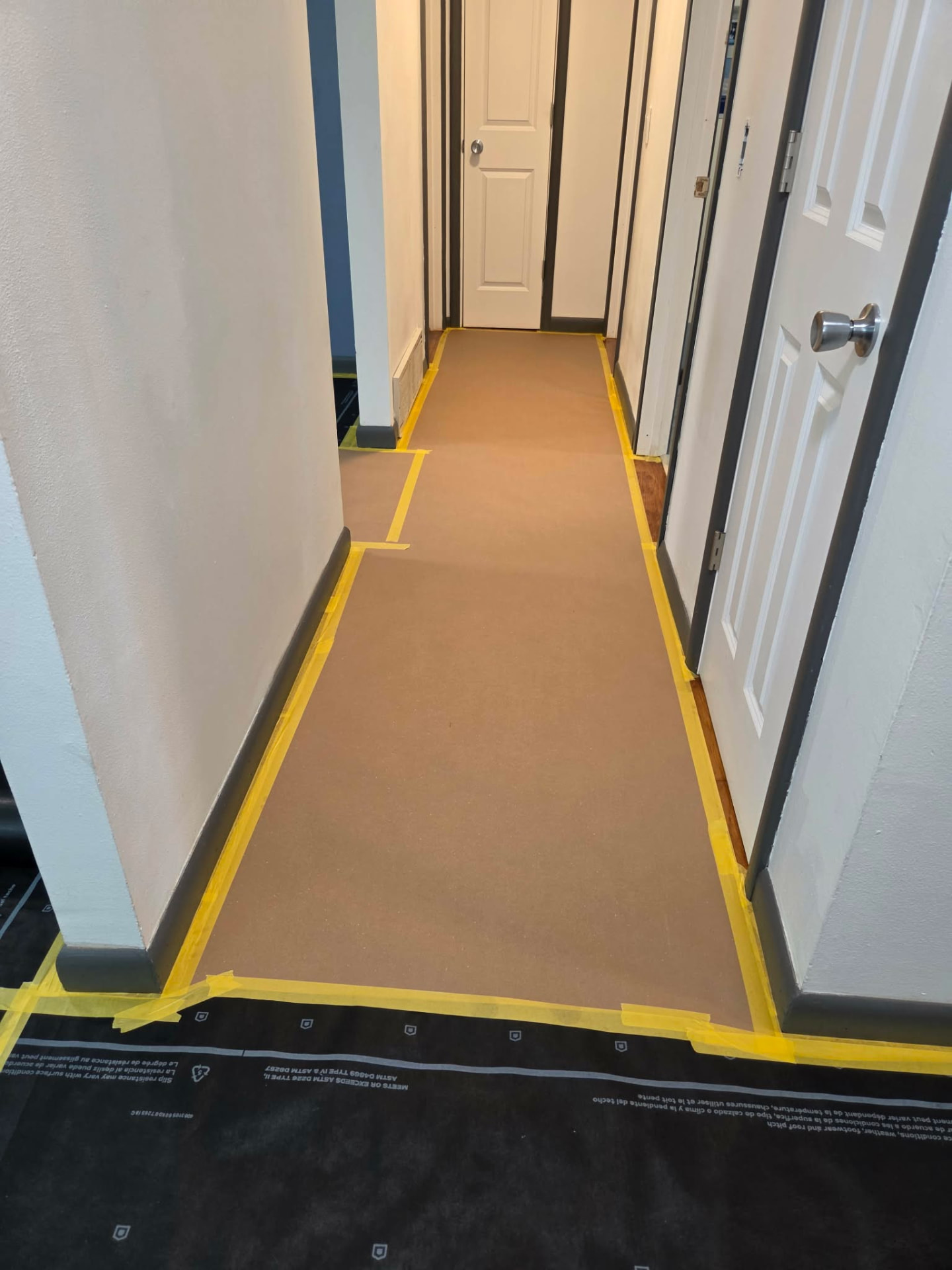 Hallway floor protected with paper and masking tape before painting